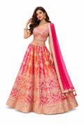 Woman wearing a traditional outfit with a pink and orange patterned dress and pink dupatta on a white background