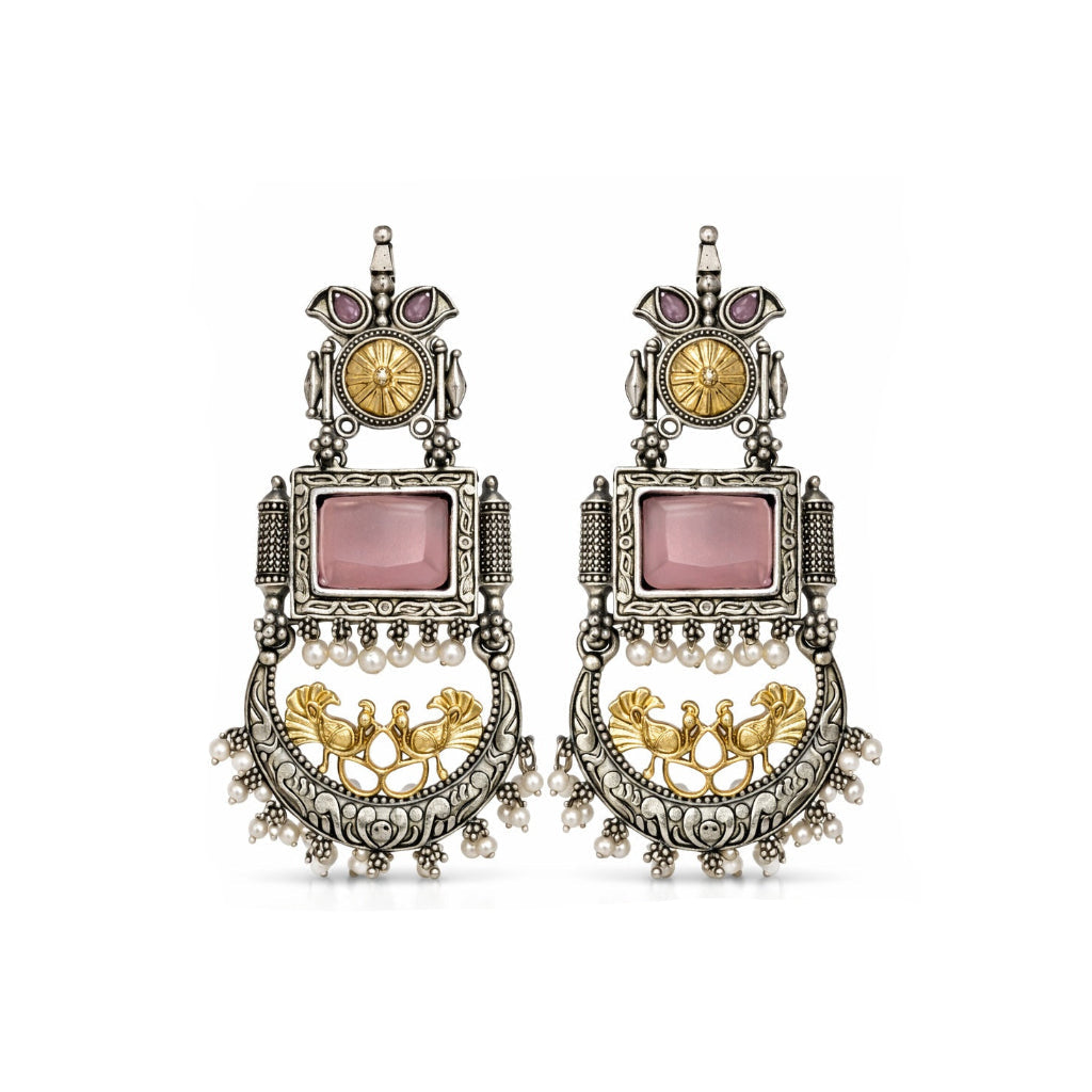 Ornate earrings with pink stones and gold accents on a white background