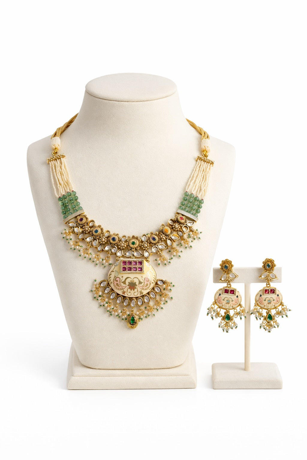 Gold necklace with green stones and matching earrings on a white background