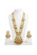 Gold necklace and earrings set on a white mannequin
