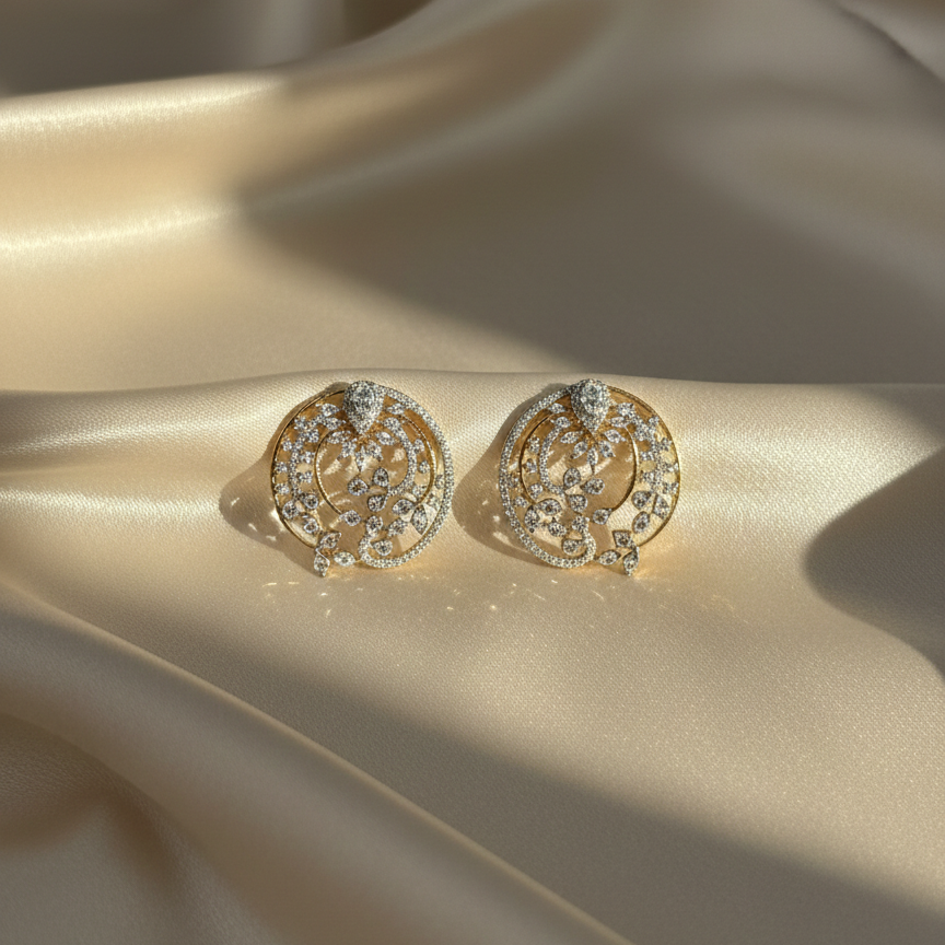 Gold earrings with gemstones on a beige fabric background