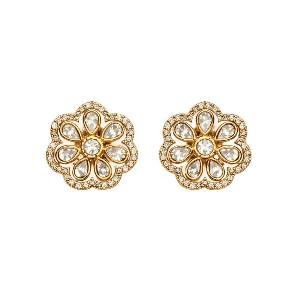 Pair of gold floral earrings with clear gemstones on a white background